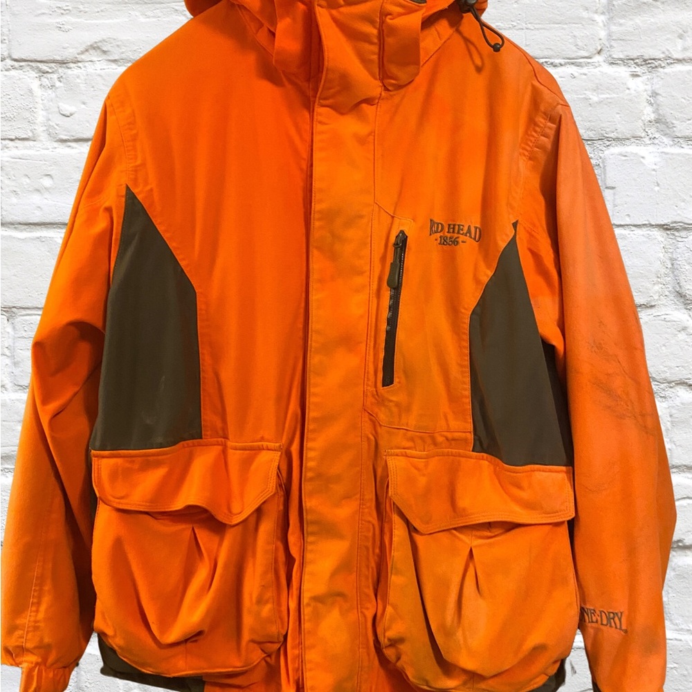 Redhead size Large, orange jacket with lots of zip up pockets.